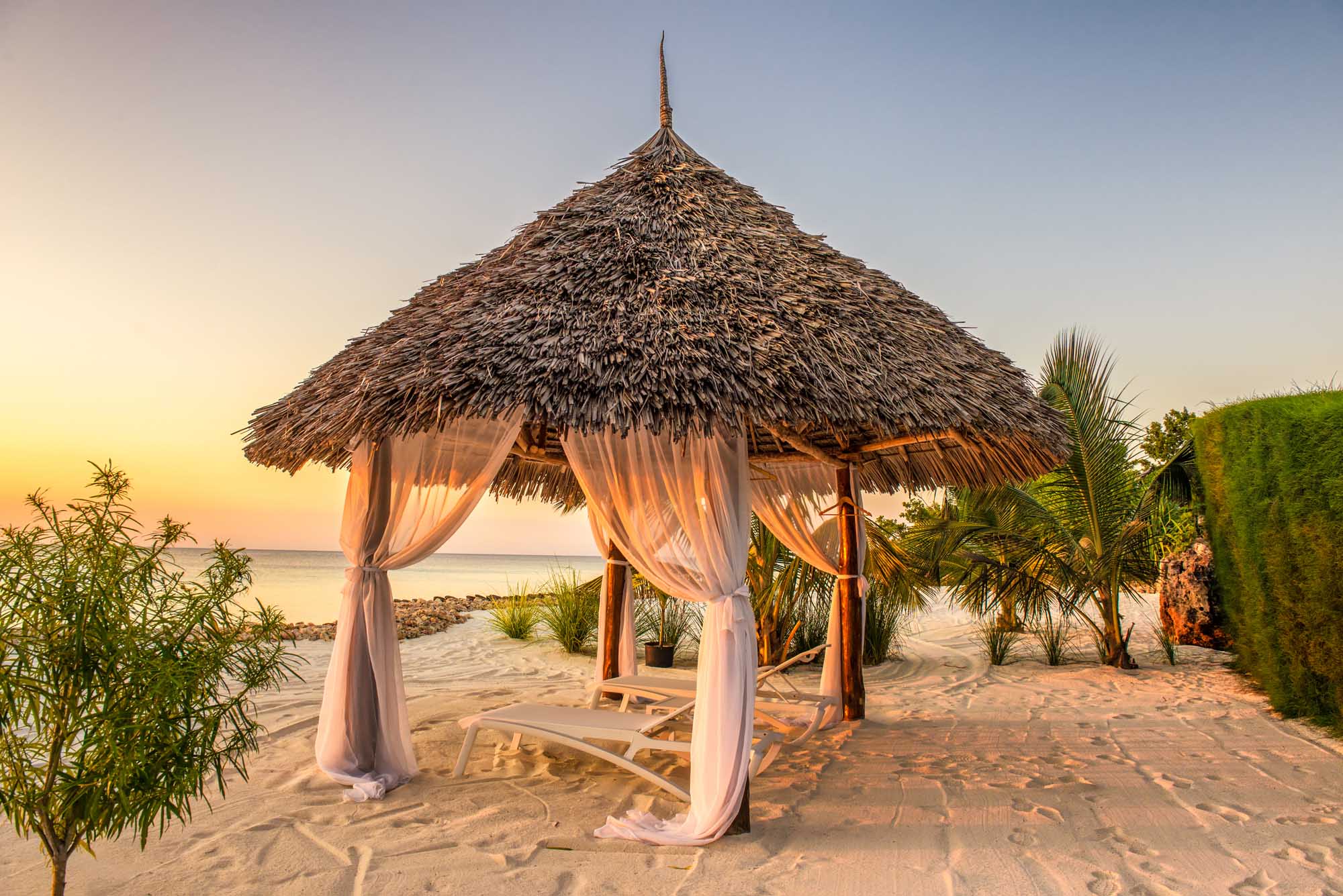 Beach lounge chairs at sunset in Zanzibar.